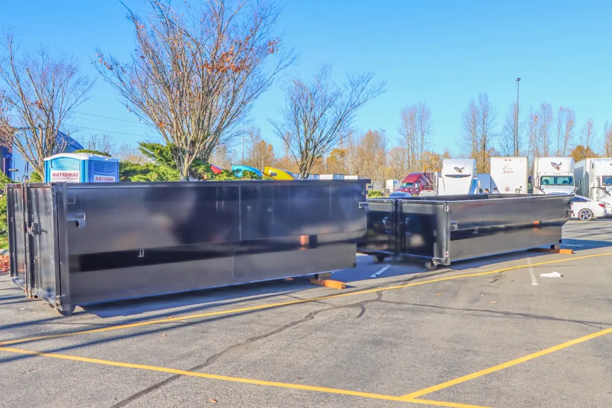 Professional dumpster rental service with roll-off container on residential driveway in Neptune